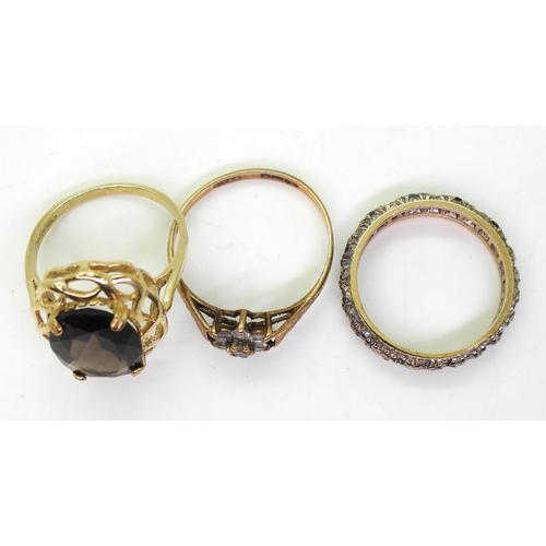 723 - Three 9ct gold rings, smoky quartz N1/2, green and clear gem eternity ring, size O1/2, and a retro c... 