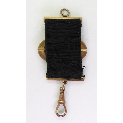 750 - A 9ct gold buckle pattern fob on black silk ribbon, weight 7gms