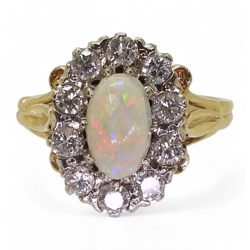 770 - An opal and diamond cluster ring, with fleur de lis shoulders, the shank is stamped K9. Size of the ... 