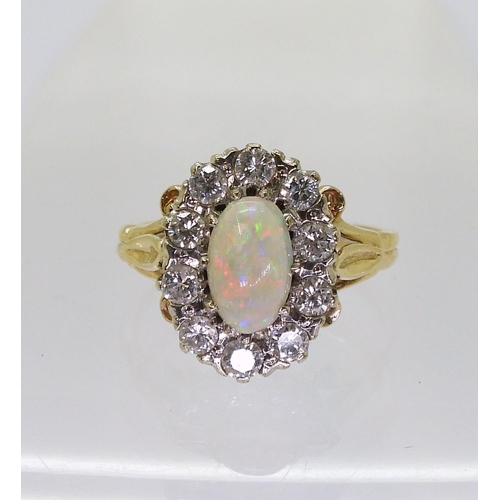 770 - An opal and diamond cluster ring, with fleur de lis shoulders, the shank is stamped K9. Size of the ... 