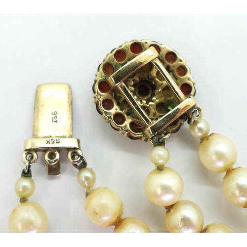 775 - A double string of pearls with a 9ct gold garnet and pearl clasp with a diameter of 18.2mm, length o... 