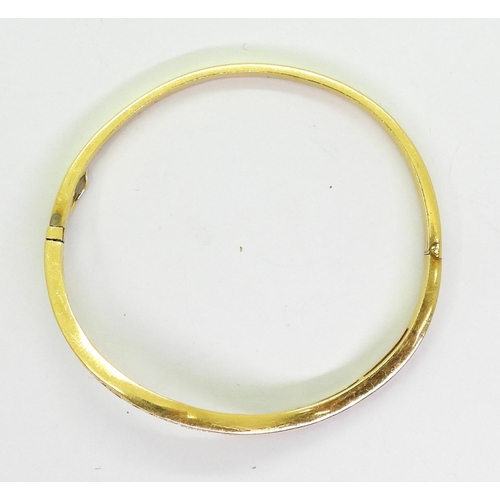 792 - A wave shaped bright yellow metal bangle, of Chinese manufacture, bearing Chinese hallmarks,  set wi... 