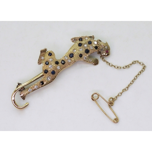 757 - A leopard brooch, the bright yellow textured body is set with sapphires and diamonds, with a ruby se... 