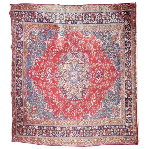 14 - A RED GROUND TABRIZ RUG with blue sunburst central medallion and blue spandrels on floral patterned ... 