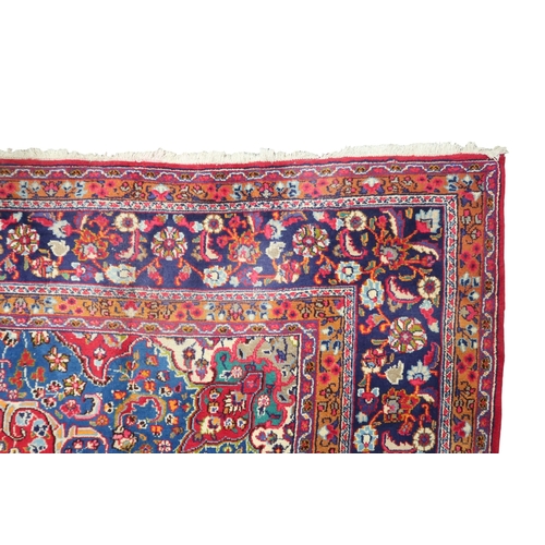 14 - A RED GROUND TABRIZ RUG with blue sunburst central medallion and blue spandrels on floral patterned ... 