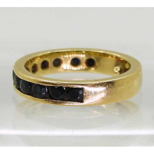 736 - A bright yellow metal eternity ring, set with round channel set sapphires, stabilising balls soldere... 