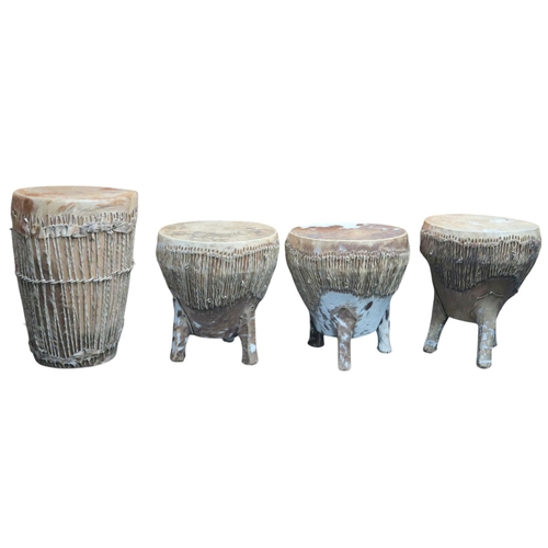 600 - Three three-legged African drums with cow hide, each c.35cm tall, and another larger double-sided hi... 