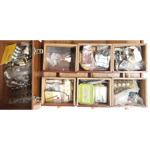 628 - A chest of drawers containing instrument repair parts to include, tuning pegs, banjo hex nuts, mothe... 