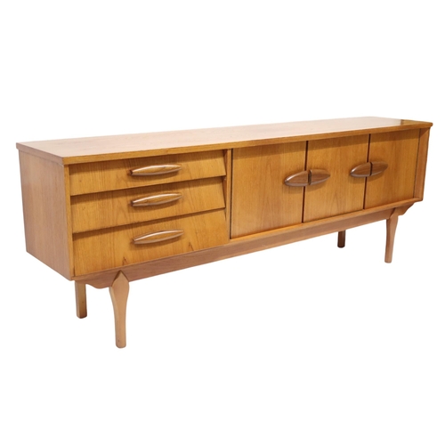 96 - A MID 20TH CENTURY TEAK JENTIQUE SIDEBOARDWith fall front drinks cabinet flanked by cabinet doors al... 