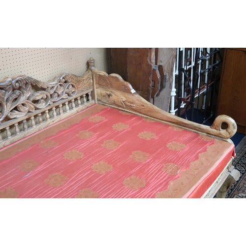 113 - A 20th century eastern style hardwood framed day bed with carved pierced foliate patterned back over... 