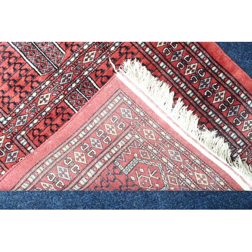 34 - A lot comprising a multicoloured geometric patterned prayer rug, 139cm long x 81cm wide and a red gr... 