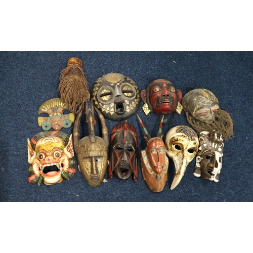 273 - A large collection of tribal masks, an Indonesian shadow puppet, another marionette example etc