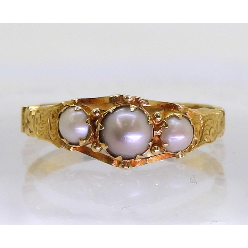 2702 - AN ANTIQUE PEARL RINGthe bright yellow metal scrolled mount with engraved detail to the shoulders. S... 