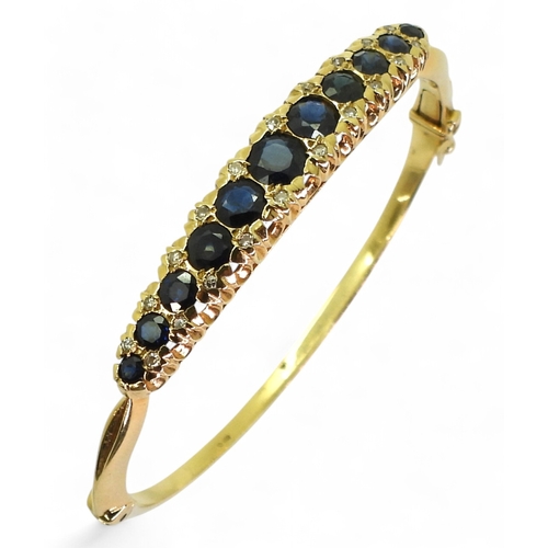 2710 - A SAPPHIRE & DIAMOND BANGLEmade in 18ct gold hallmarked London 1975. The scalloped galleried mou... 