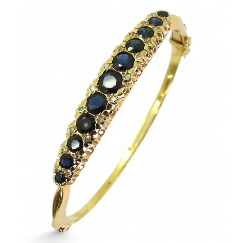 2710 - A SAPPHIRE & DIAMOND BANGLEmade in 18ct gold hallmarked London 1975. The scalloped galleried mou... 