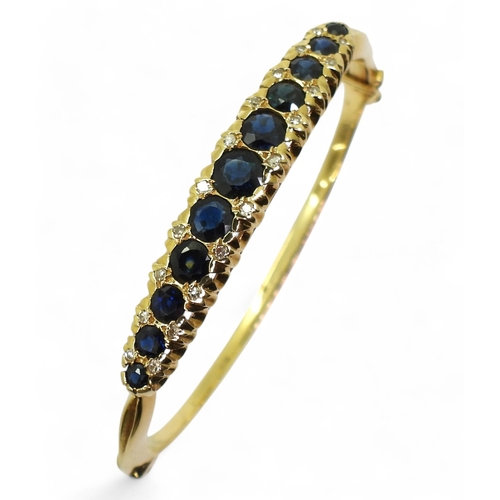 2710 - A SAPPHIRE & DIAMOND BANGLEmade in 18ct gold hallmarked London 1975. The scalloped galleried mou... 