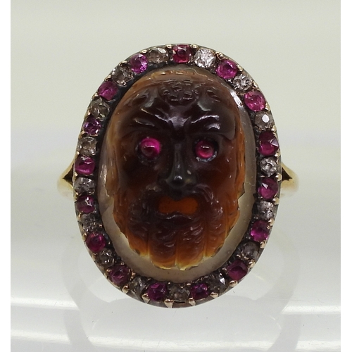 2720 - AN AGATE CAMEO RINGclassical mask themed cameo, carved in brown and cream agate, with ruby eyes. mou... 