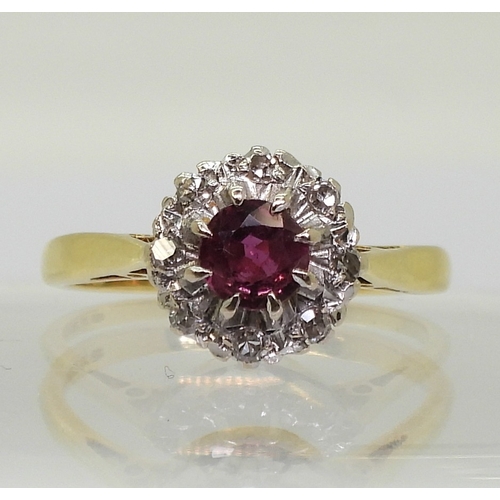 2723 - A RETRO CLUSTER RINGset with a central 4.9mm round cut ruby, surrounded with diamond accents to the ... 