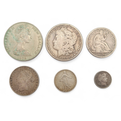 464 - A collection of worldwide coins in two collector's folders to include 1873 Liberty Dollar and a 1901... 