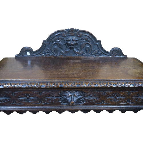 17 - An early 20th century oak baronial style carved hall table with carved scrolled lion masque gallery ... 