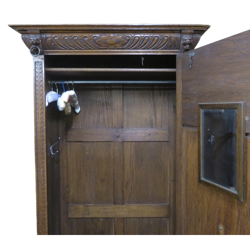 22 - A late 19th century oak baronial style single door hall robe with moulded cornice over extensively c... 