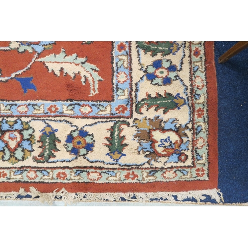 37 - A terracotta ground Zeigler style rug with floral/foliate patterned ground within cream floral borde... 