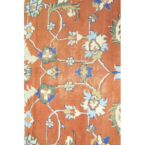 37 - A terracotta ground Zeigler style rug with floral/foliate patterned ground within cream floral borde... 