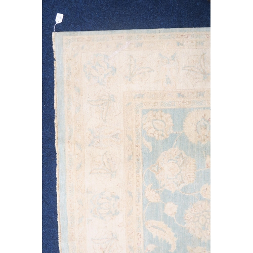 40 - A turquoise ground Zeigler rug with cream all over floral/foliate patterned ground within cream flor... 