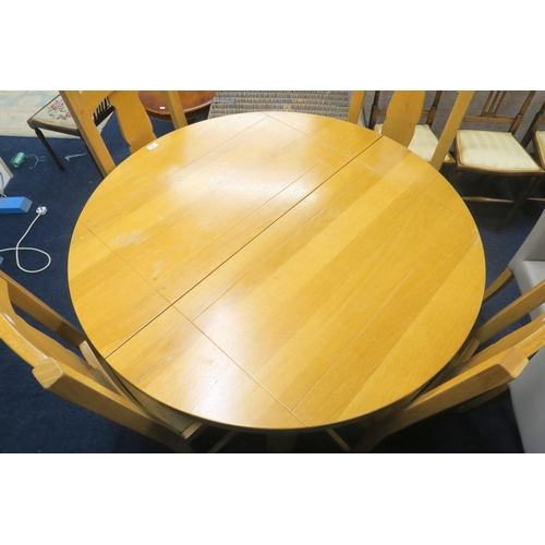 48 - A contemporary teak extending dining table and four chairs, table with circular top concealing inter... 