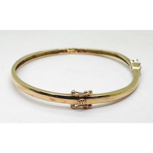 722 - A 9ct gold bangle set with three diamonds, with an estimated approx diamond total of set with 20cts ... 