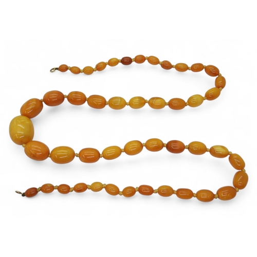 739 - A string of butterscotch amber beads, largest bead 26mm x 20mm, smallest 9.7mm x 7.3mm, overall leng... 