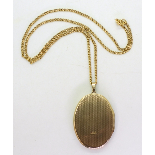 746 - A 9ct gold large oval locket with engraved detail, made by JA Main Ltd Birmingham, on a 50cm 9ct gol... 