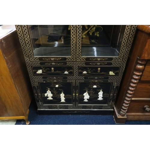 75 - A 20th century Oriental style black lacquer display cabinet with pair of glazed doors over two short... 