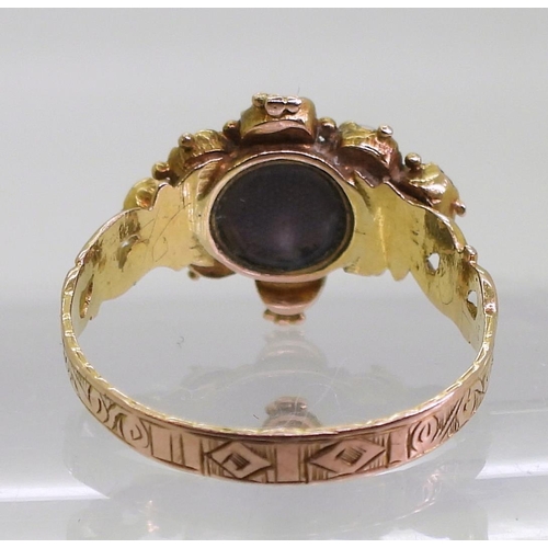 779 - An unusual 12ct (twelve) vintage garnet and pearl flower mourning ring, a small glazed panel is behi... 