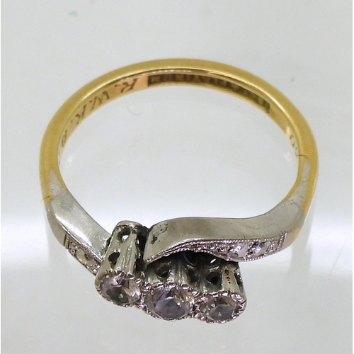 800 - An 18ct and platinum three clear gems on a twist, (possibly white sapphire) finger size N, weight 3.... 