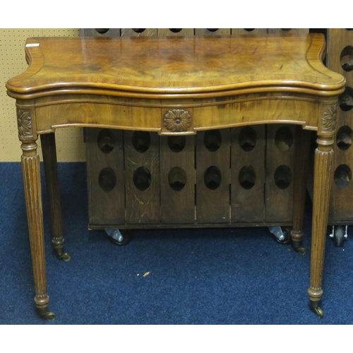 84 - A 19th century walnut veneered serpentine front fold over card table on turned reeded supports, 76cm... 