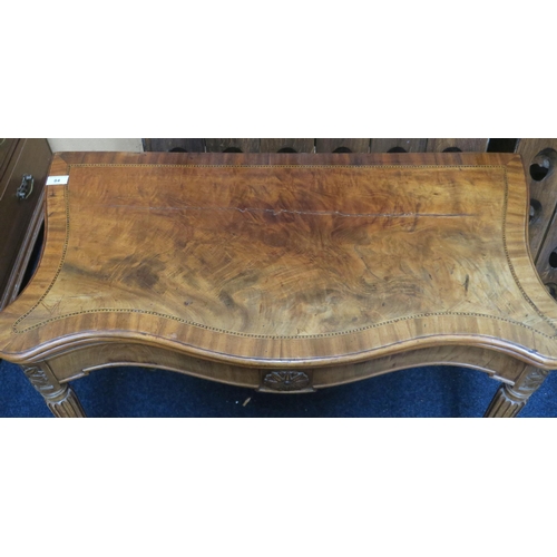 84 - A 19th century walnut veneered serpentine front fold over card table on turned reeded supports, 76cm... 