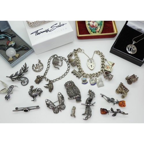 879 - A collection of silver and marcasite brooches to include an owl and a rooster, two silver charm brac... 