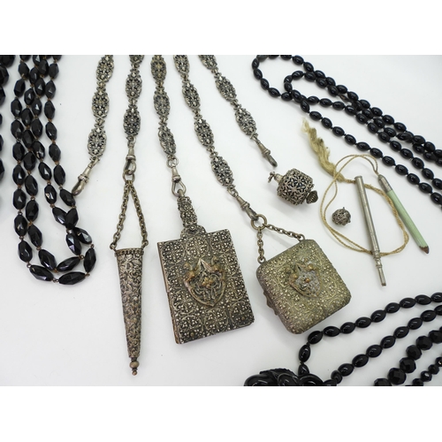 881 - A partial base metal chatelaine with a mythical beast theme, together with a selection of black glas... 