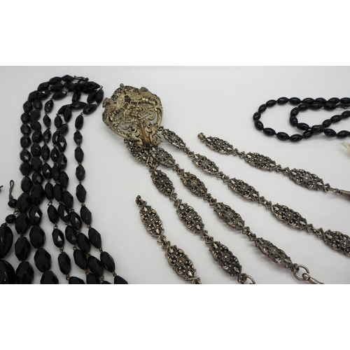 881 - A partial base metal chatelaine with a mythical beast theme, together with a selection of black glas... 