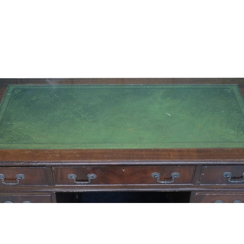 9 - A 20th century mahogany pedestal writing desk with green writing skiver top over central drawer flan... 