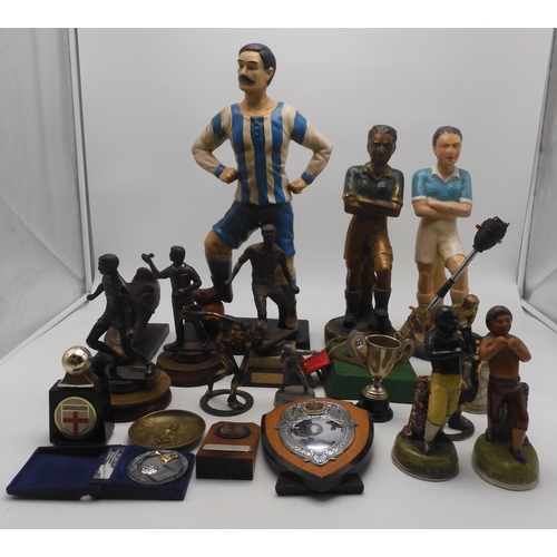 606 - Assorted figures of sportsmen, comprising a large ceramic moustached footballer standing approx. 52c... 