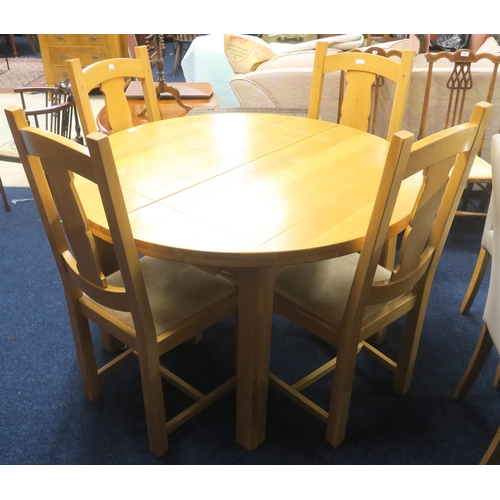 48 - A contemporary teak extending dining table and four chairs, table with circular top concealing inter... 