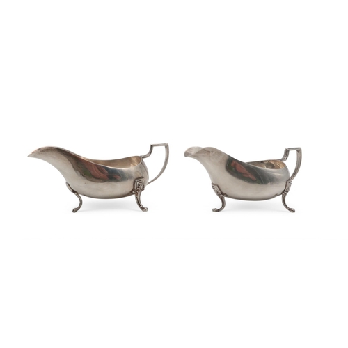 303 - A pair of silver sauce boats, by Elkington & Co, Birmingham 1931, with stylised legs and handles... 