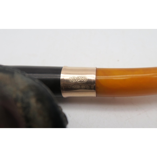 403 - A leather-cased 9ct gold-collared amber-handled Meerschaum pipe, with bowl modelled as an Edwardian ... 