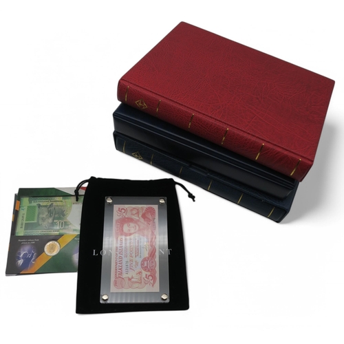 364 - A world wide collection of banknotes in three albums together with A Falklands Islands £5 1983... 