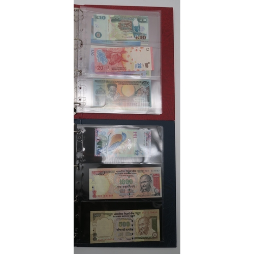 364 - A world wide collection of banknotes in three albums together with A Falklands Islands £5 1983... 