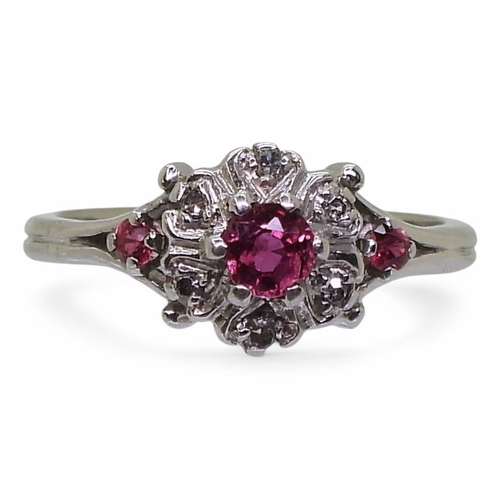 702 - An unusual 18ct white gold ruby and diamond flower ring, size K1/2, weight 3gms