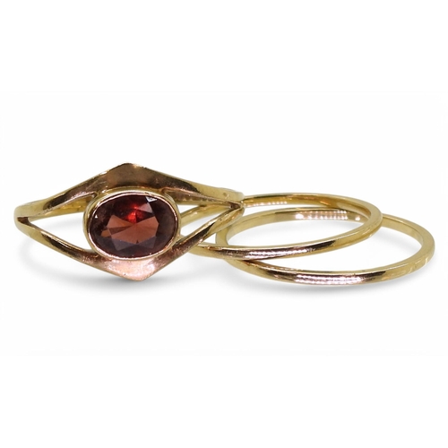 778 - A 9ct gold garnet ring, together with two yellow metal band rings, weight combined 2.9gms