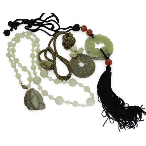 870 - A collection of Chinese green hardstone to include;- a string of pale green beads carved with symbol... 